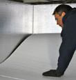 A contractor installing TerraBlock floor insulation in a Oakland crawl space